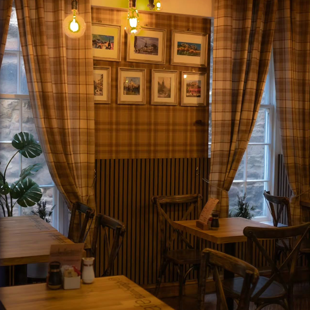 A candlelit corner table with a book and a cup of black coffee